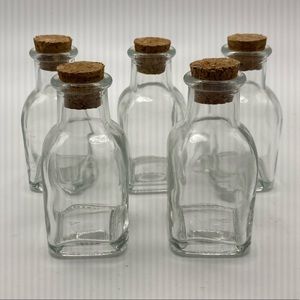 Five small jars with cork topper.